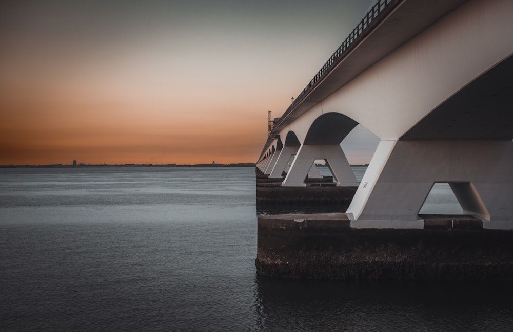 a bridge over a body of water at sunset