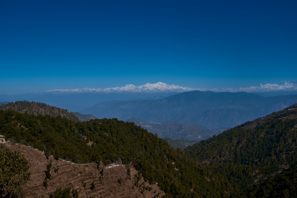 a view of a mountain range with a house in the foreground