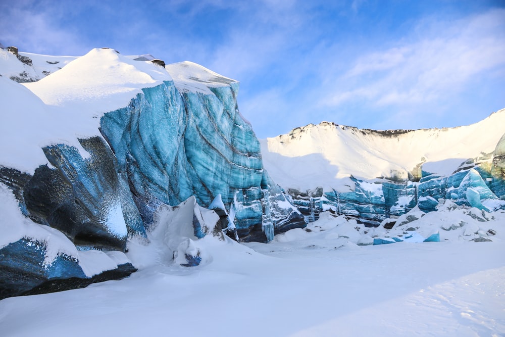 a snow covered mountain with a large iceberg in the background