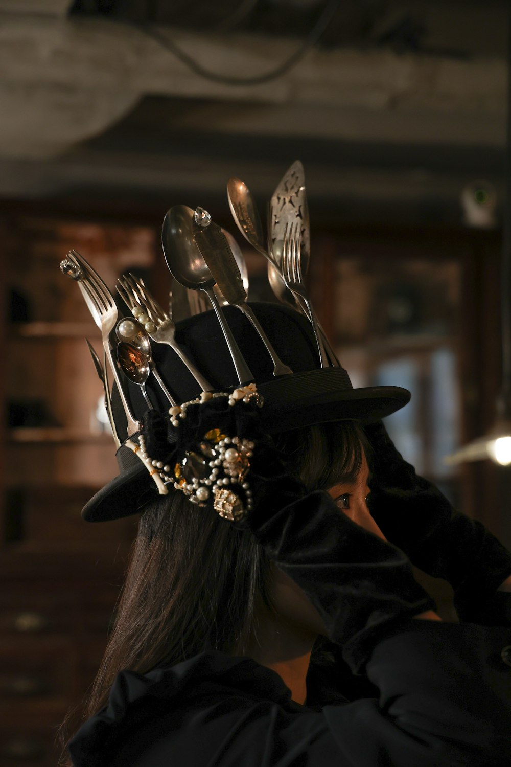 a woman wearing a hat with forks and spoons on it