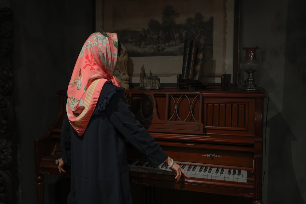 a woman in a hijab playing a piano