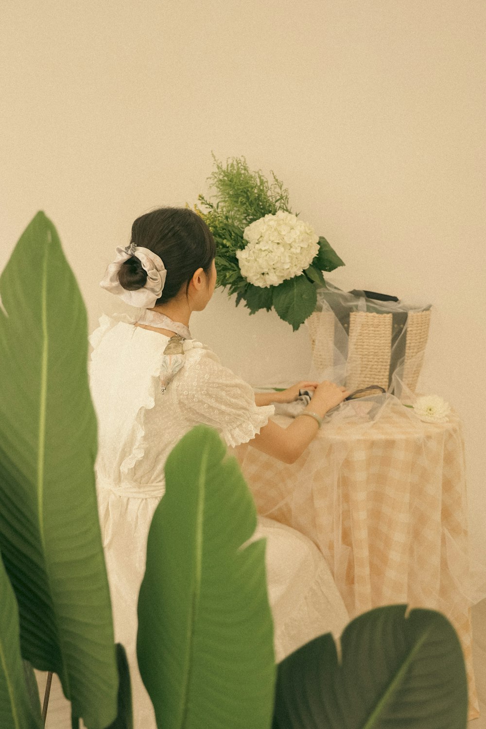 a woman in a white dress sitting at a table