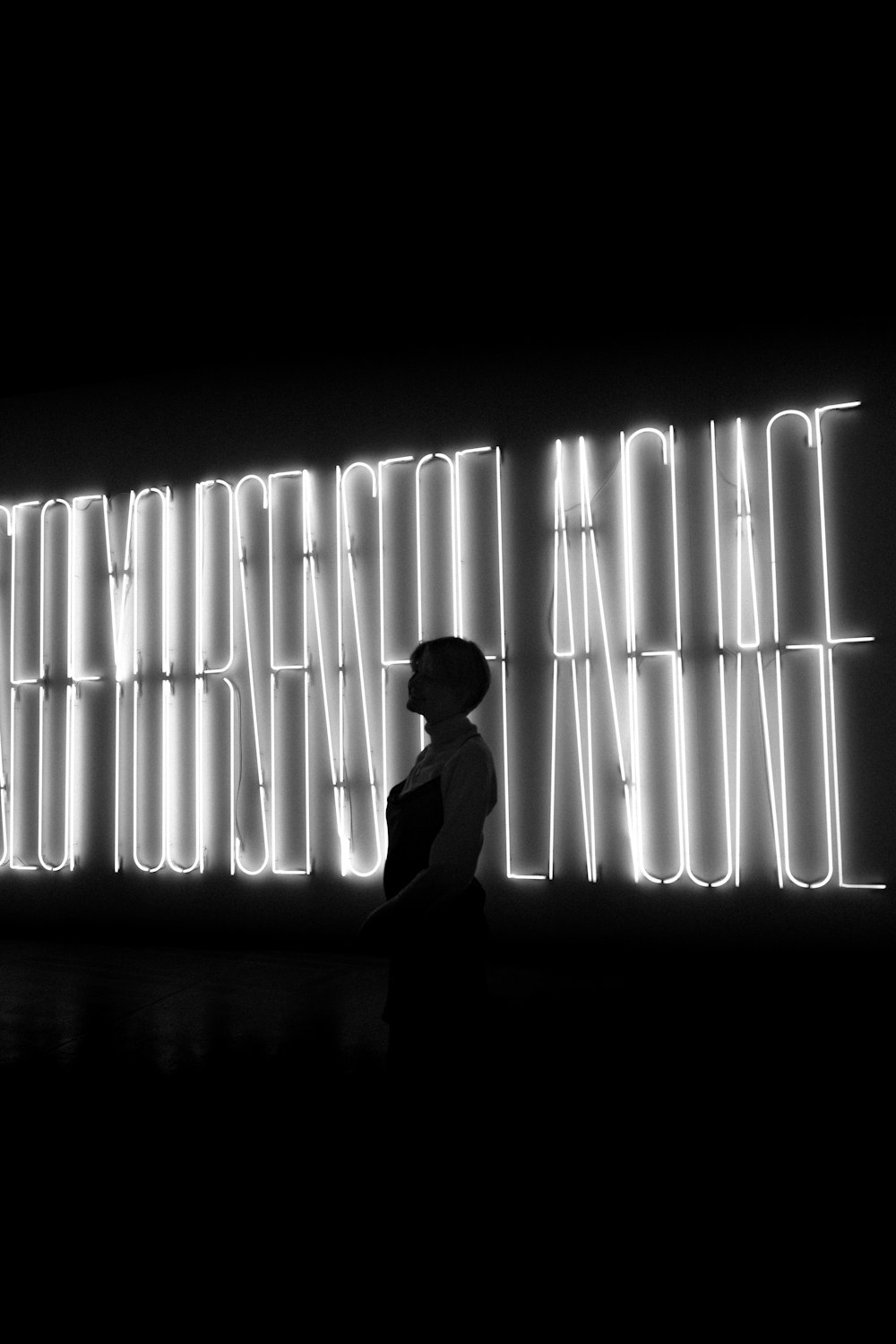 a person standing in front of a neon sign