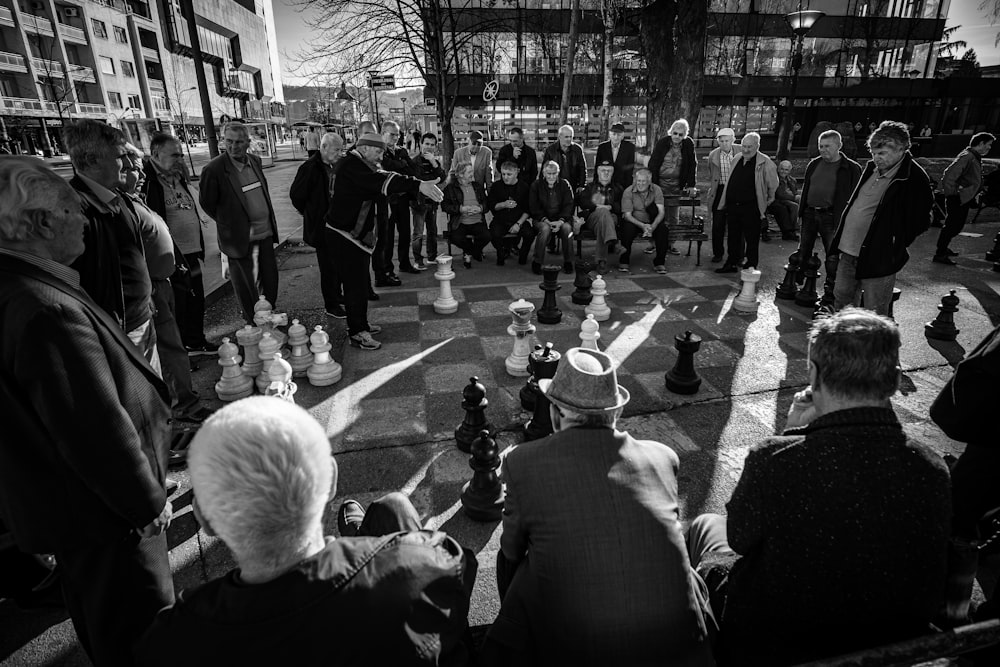 a black and white photo of people playing chess