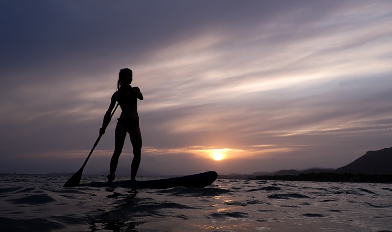 Person standing on paddle board on the water
