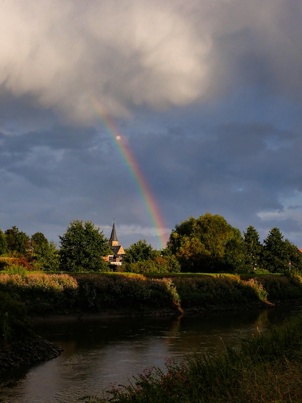 a rainbow in the sky over a river