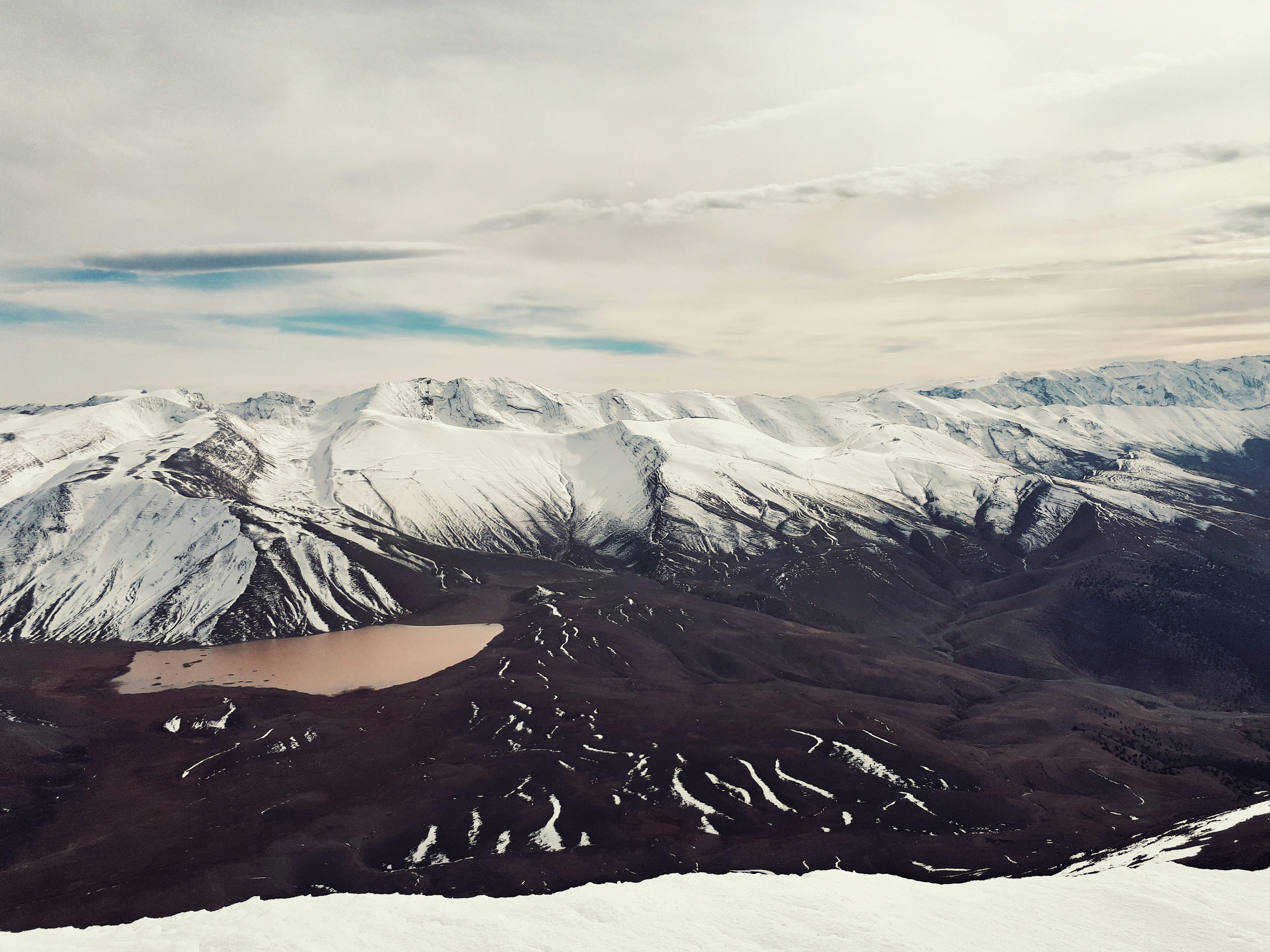 a snow covered mountain with a lake in the middle