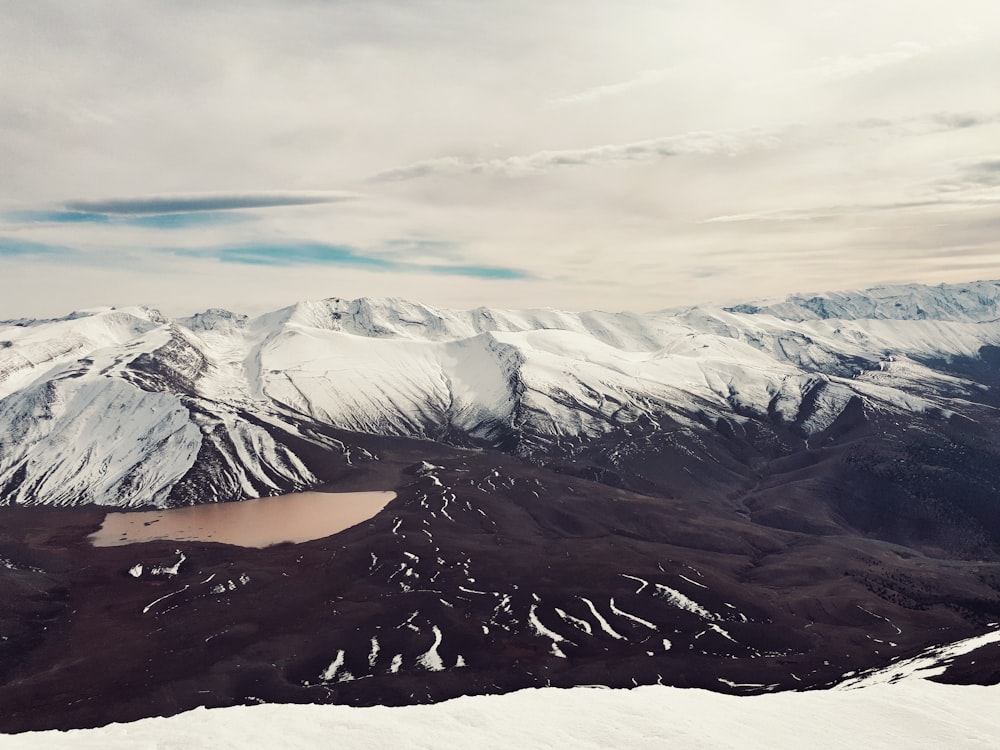 a snow covered mountain with a lake in the middle