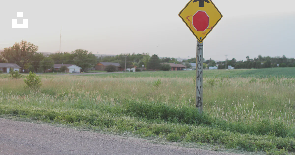 A yellow and red sign sitting on the side of a road photo – Free Symbol ...