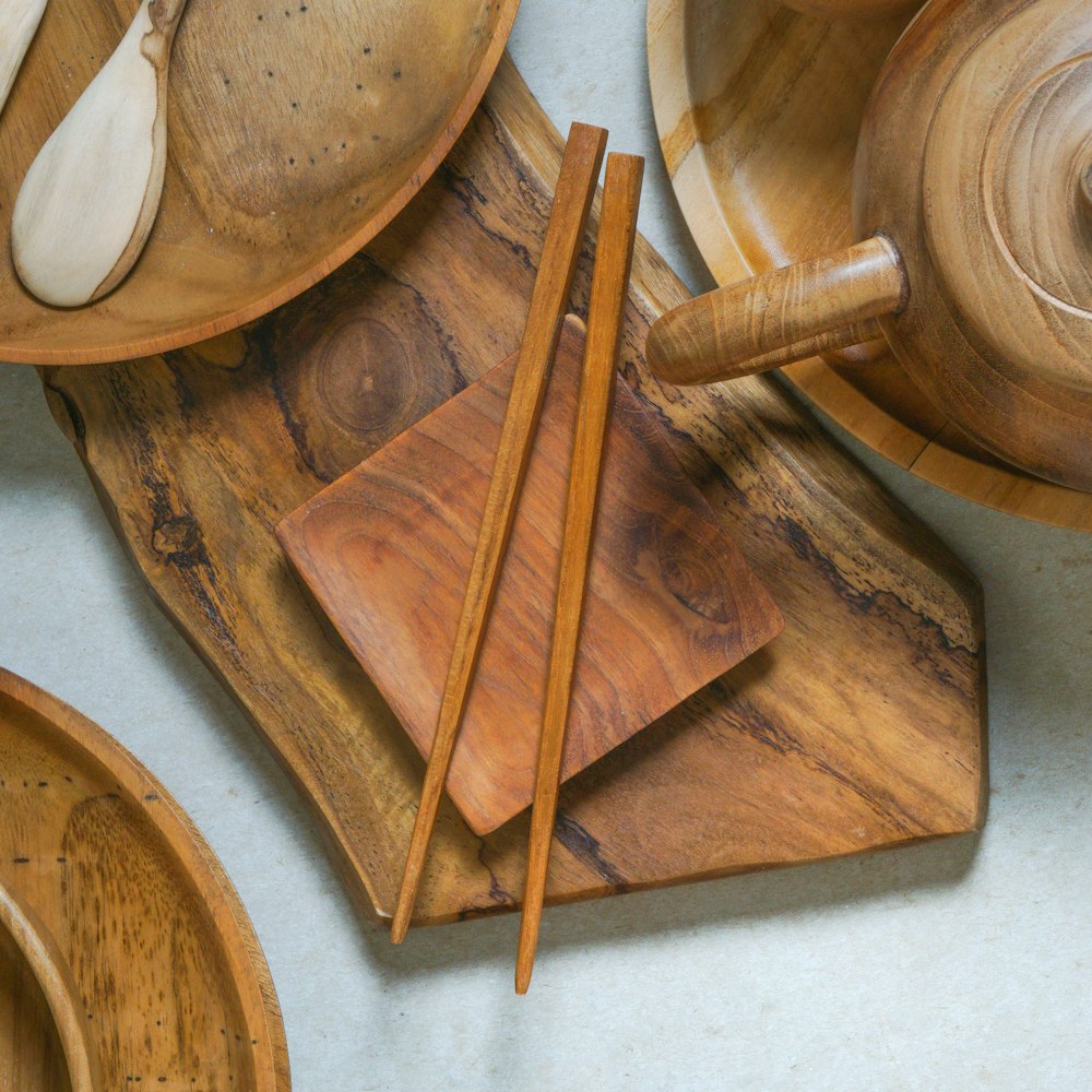 a table topped with wooden plates and wooden utensils