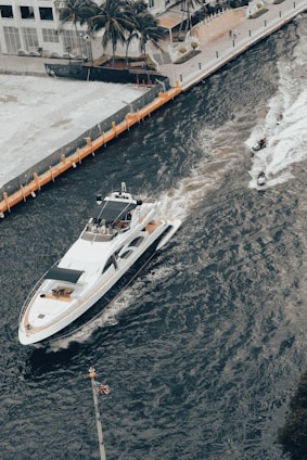 A captain steering a sleek yacht along the sunny Palm Beach coastline.
