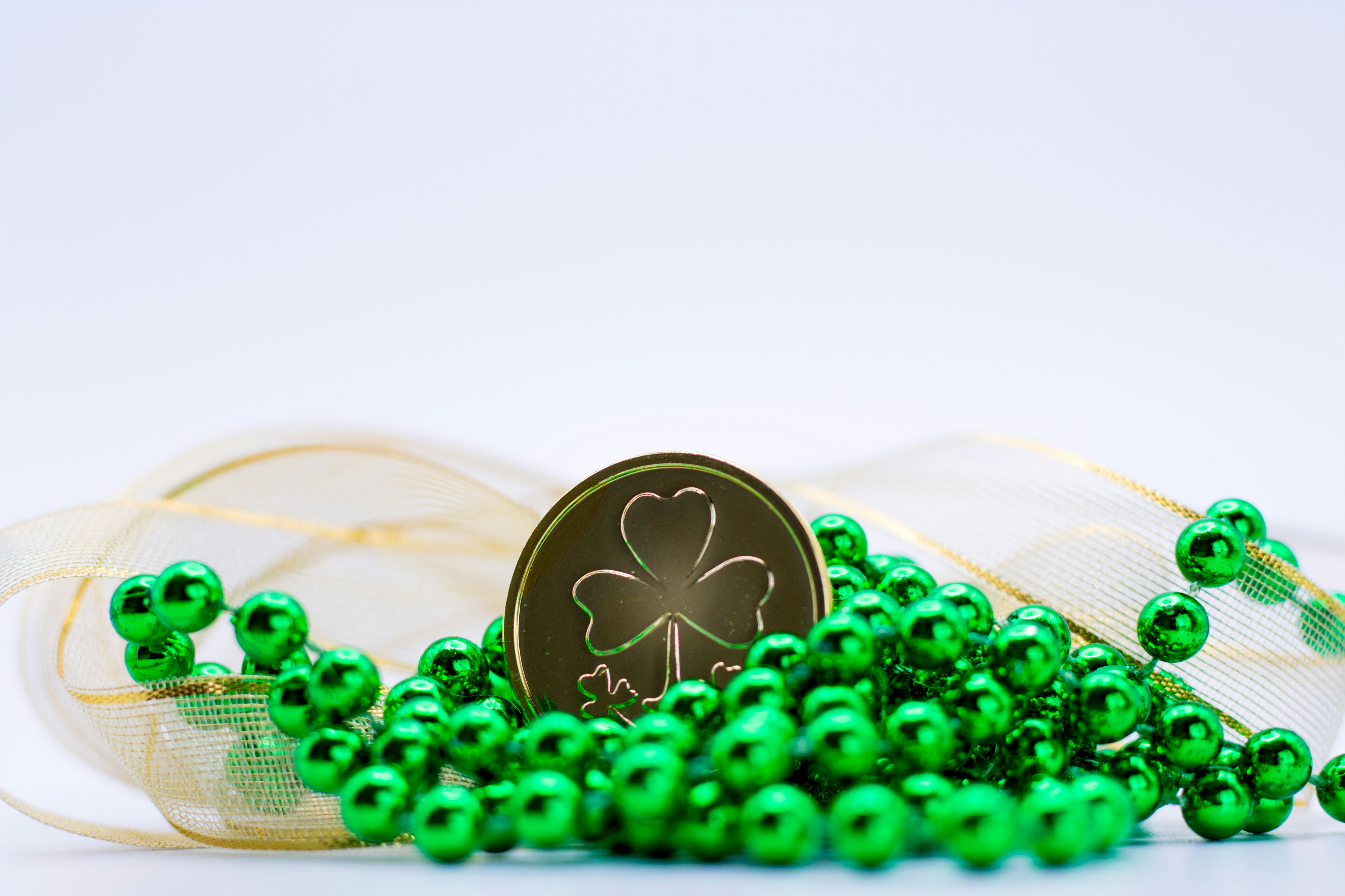 a pile of green beads with a shamrock on top