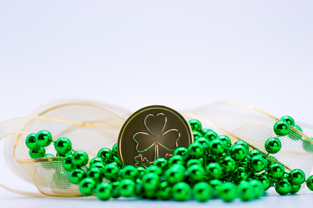 a pile of green beads with a shamrock on top