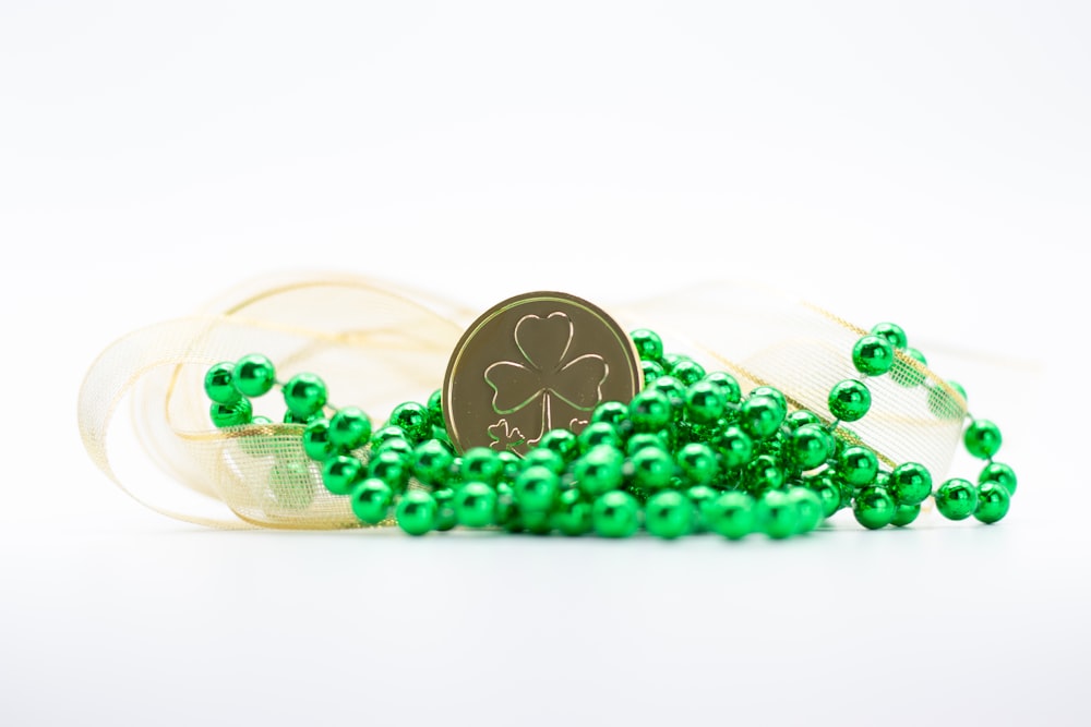 a pile of green beads next to a coin