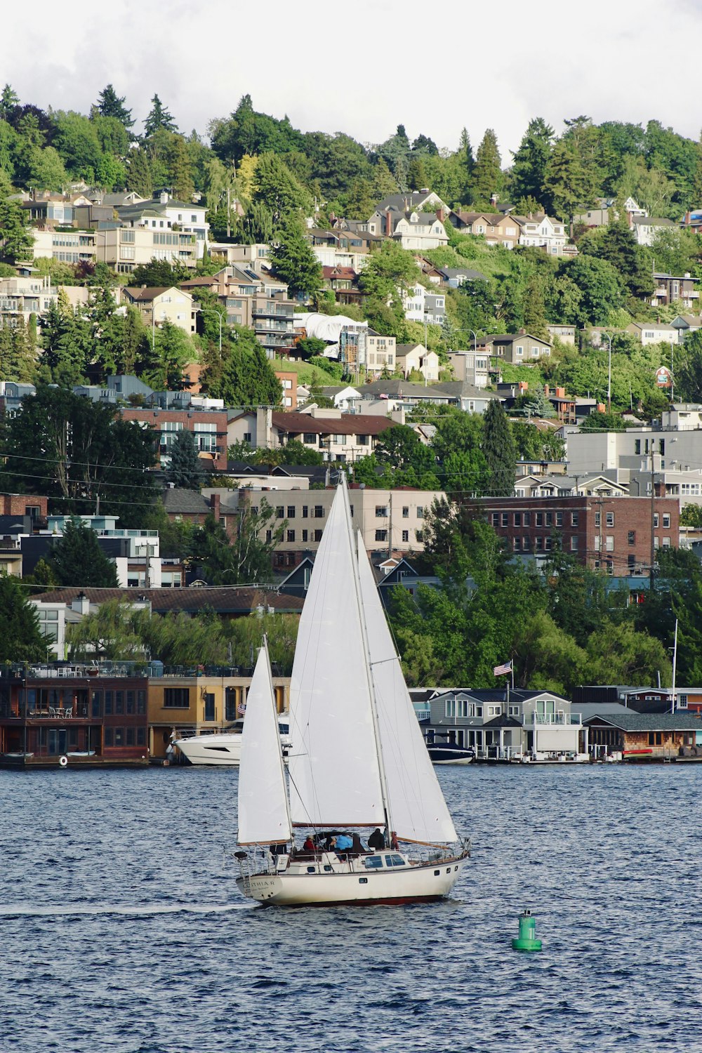 a sailboat in a body of water with a city in the background