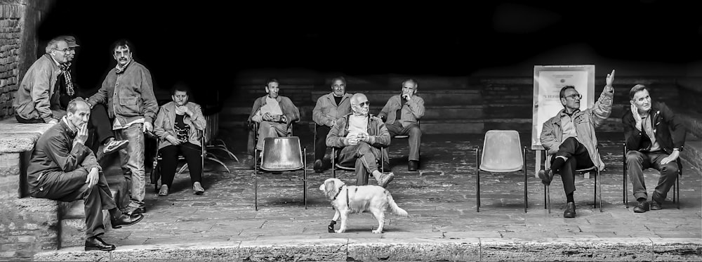a black and white photo of a group of people and a dog