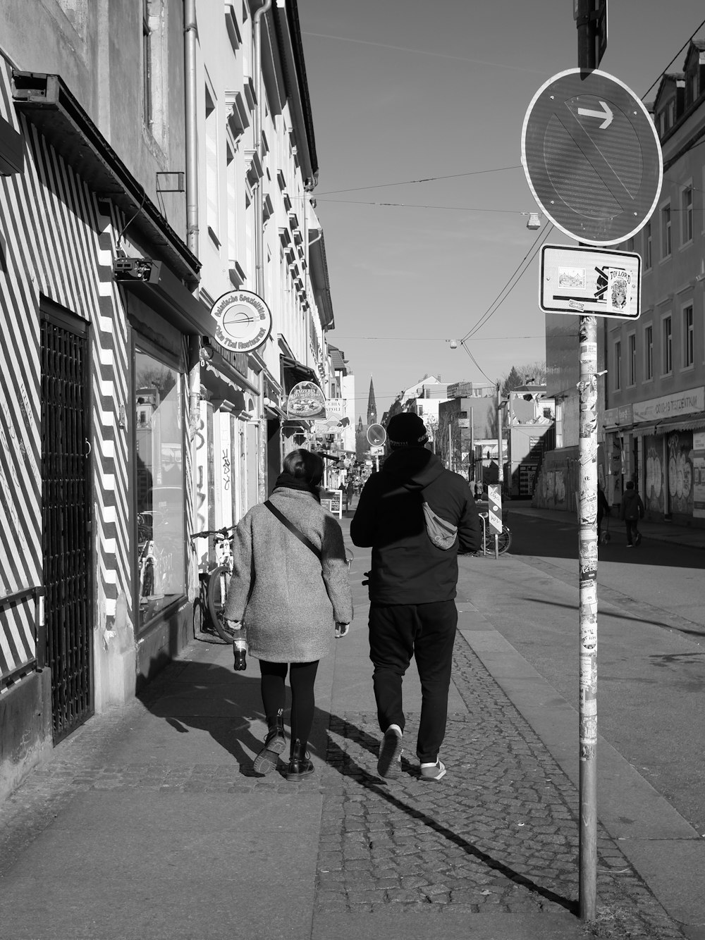 a couple of people walking down a street