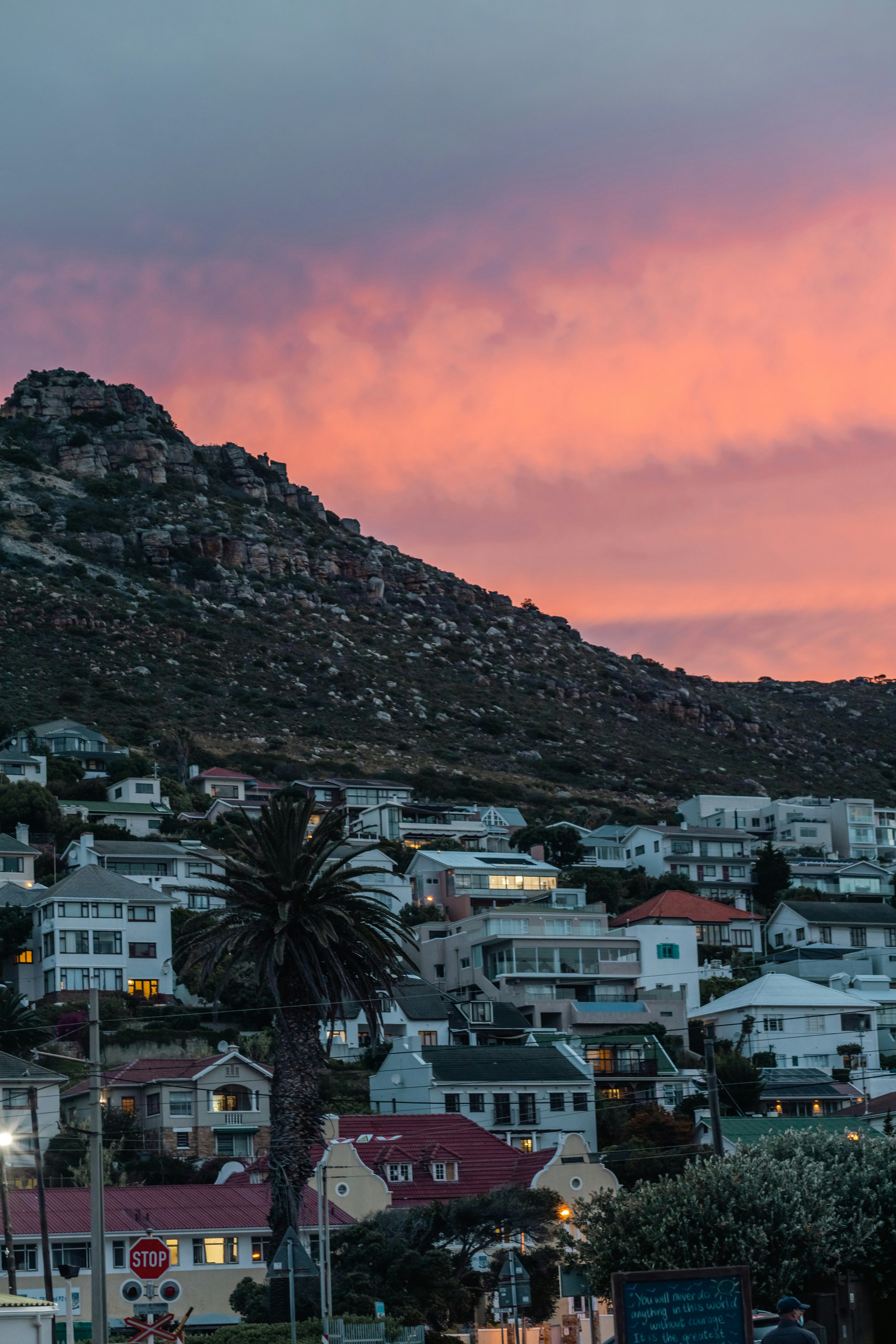 Cape Town suburb at sunset with mountain backdrop and lit homes