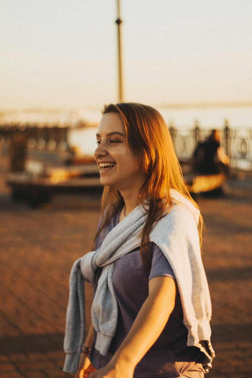 a woman walking down a street with a scarf around her neck