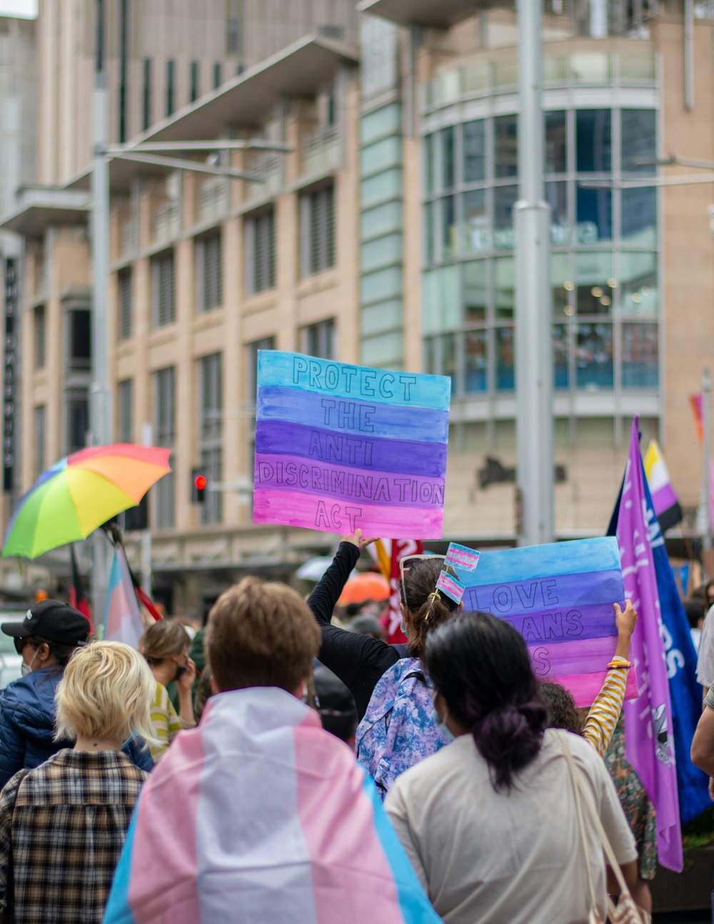 a group of people walking down a street holding signs