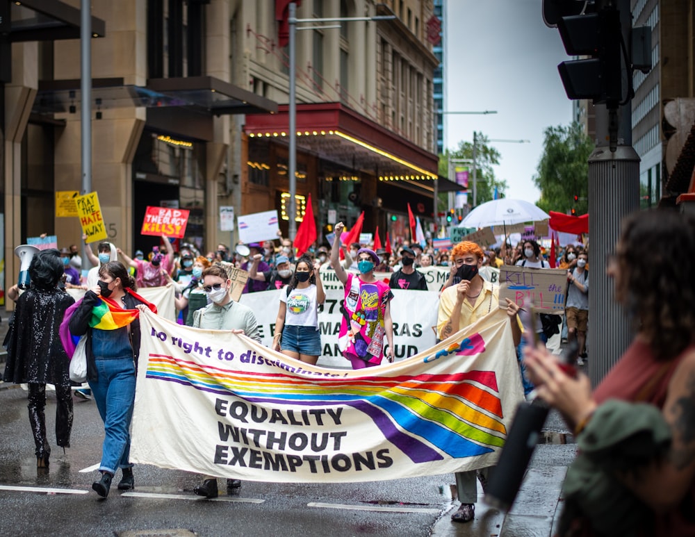 a group of people walking down a street holding a banner