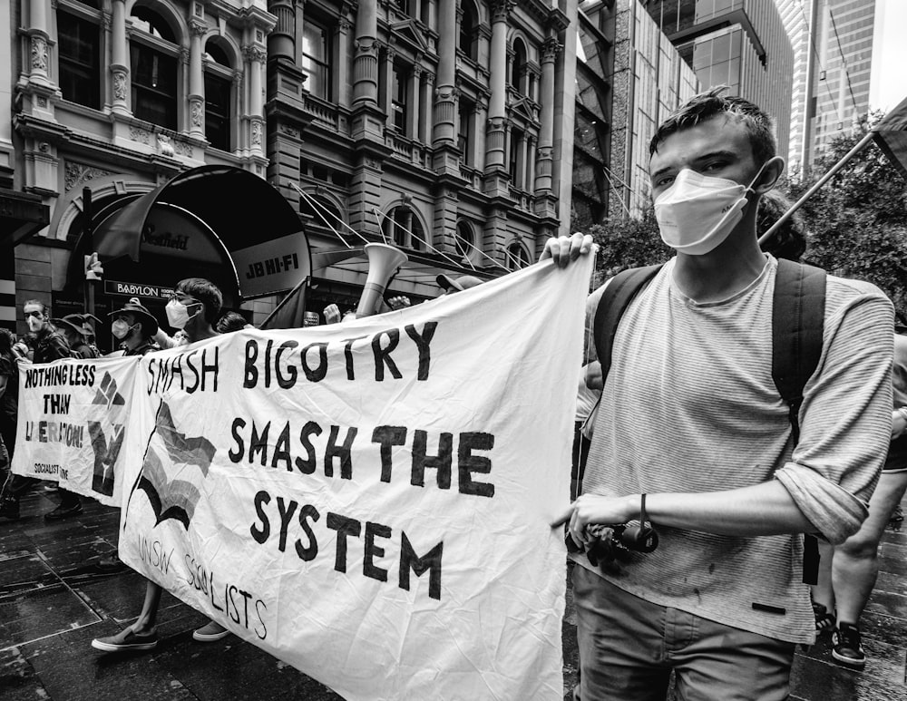 a group of people walking down a street holding a banner