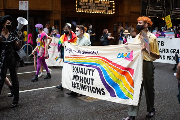 Marchers at a gay rights rally holding a sign that says "Equality Without Exemptions"