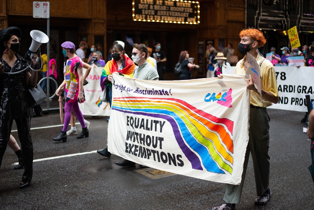 a group of people walking down a street holding a banner