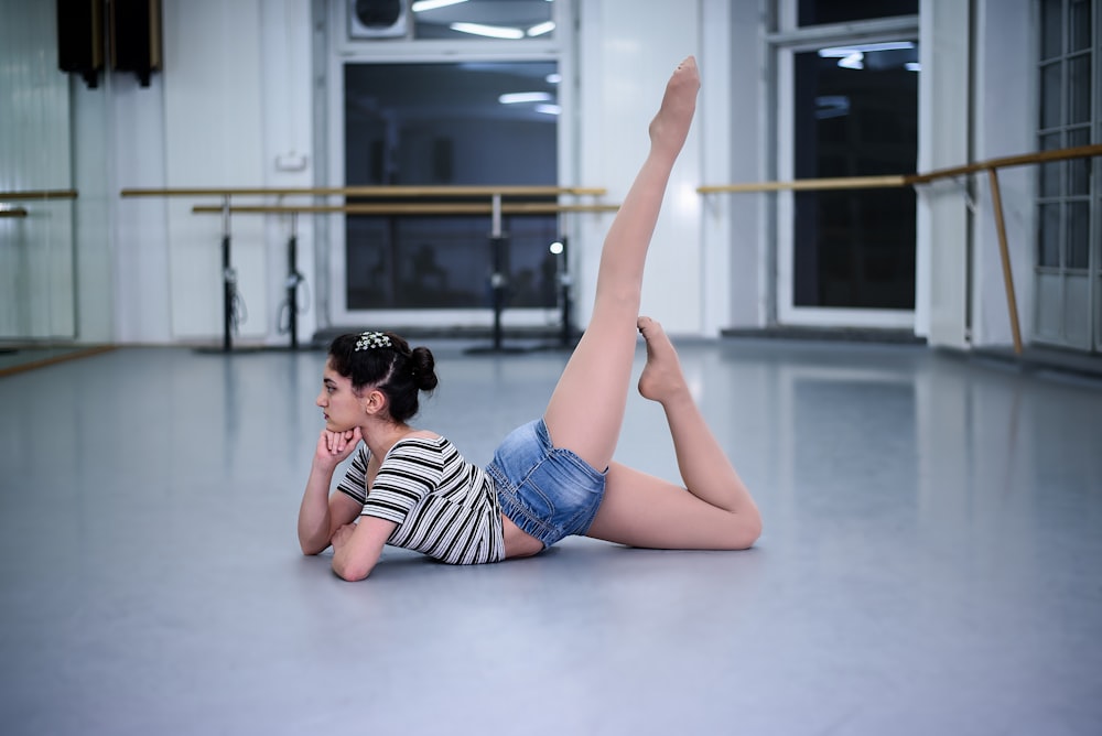 a woman laying on the floor in a dance studio