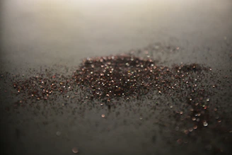 Close-up of pure silver granules shining under soft light on a dark surface.