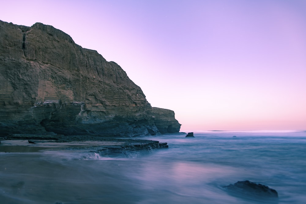 a rocky beach with waves coming in to shore