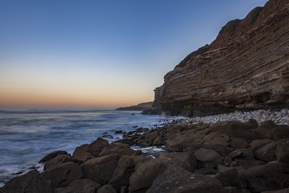 a rocky shore line with a body of water in the distance