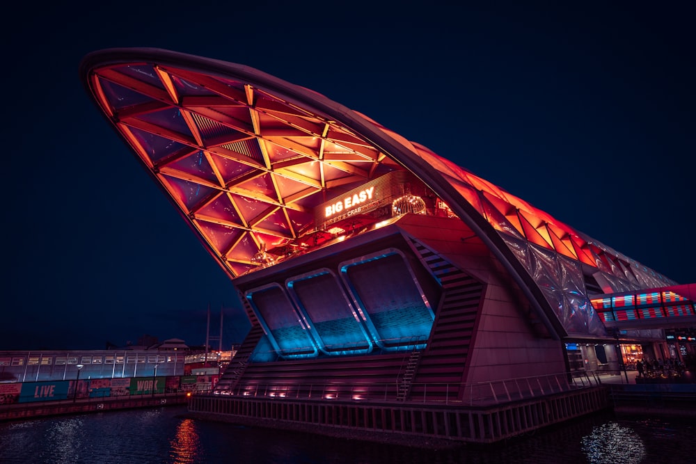 a large building with a red roof next to a body of water