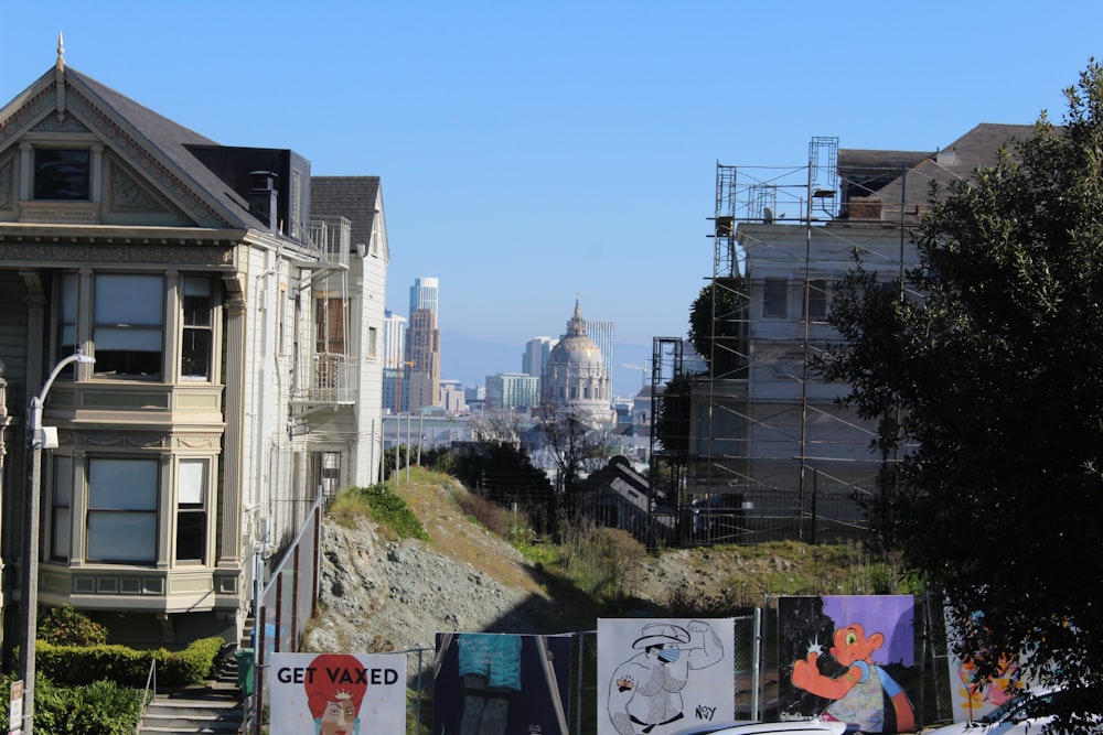 a row of houses on a hill with a city in the background