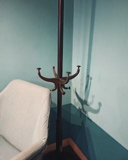 A sleek industrial metal coat rack standing proudly in a cozy entryway with warm lighting.