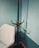 A modern living room corner featuring a sleek coat rack with jackets and scarves.