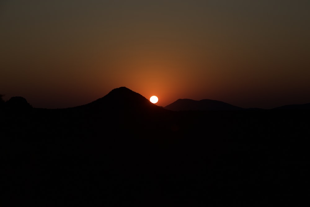 Die Sonne geht über einer Bergkette unter