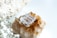 A necklace with several clear, faceted crystal pendants is placed on top of a cluster of amber-hued crystals. In the foreground, delicate white baby's breath flowers are visible, adding a soft, natural touch to the composition.