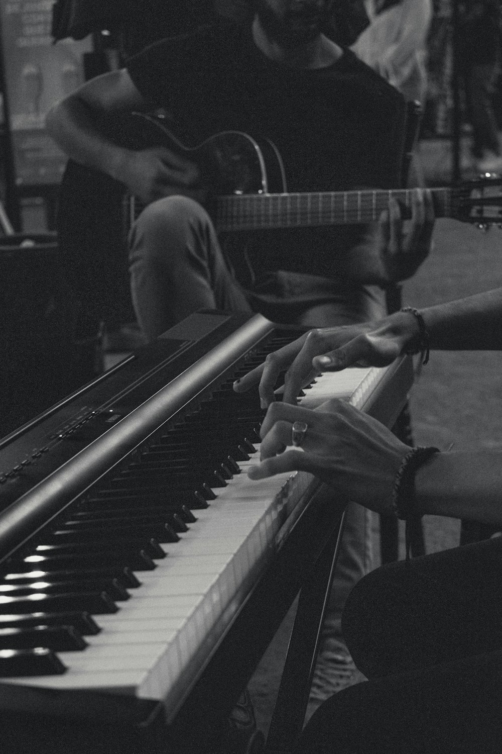 a man sitting at a piano playing a guitar