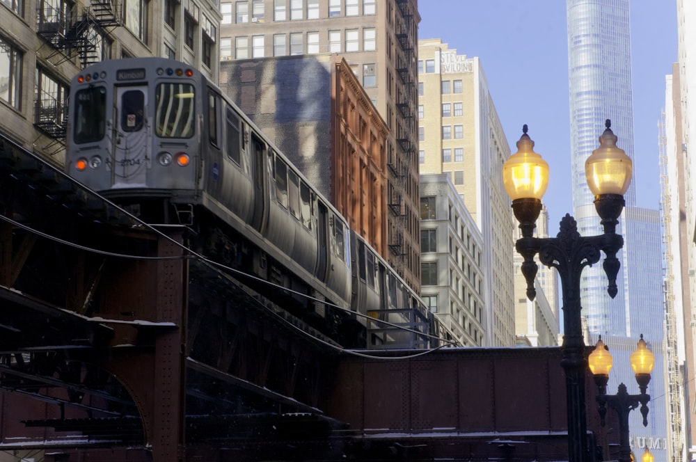 a train traveling over a bridge next to tall buildings