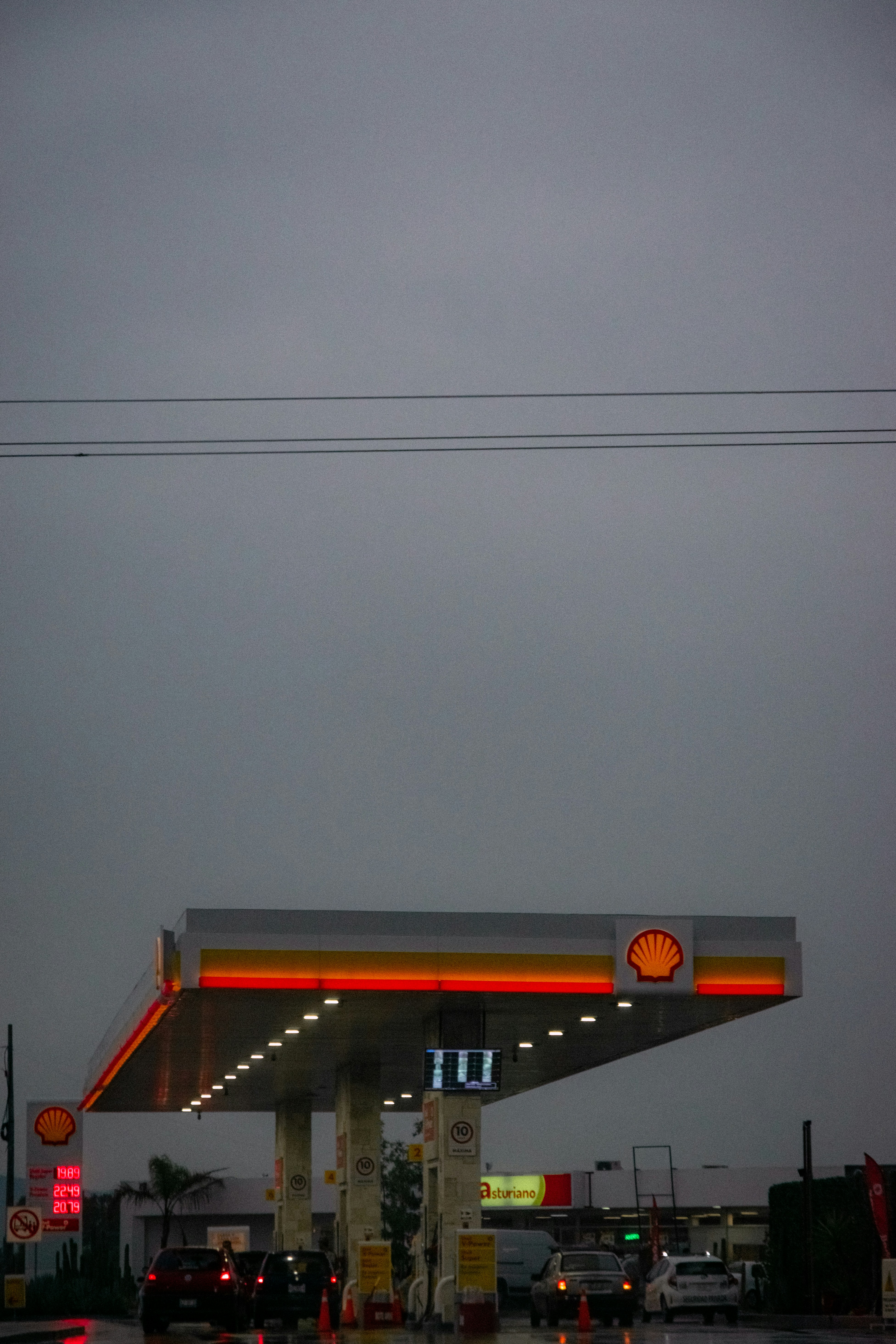 a gas station with cars parked at the gas pump
