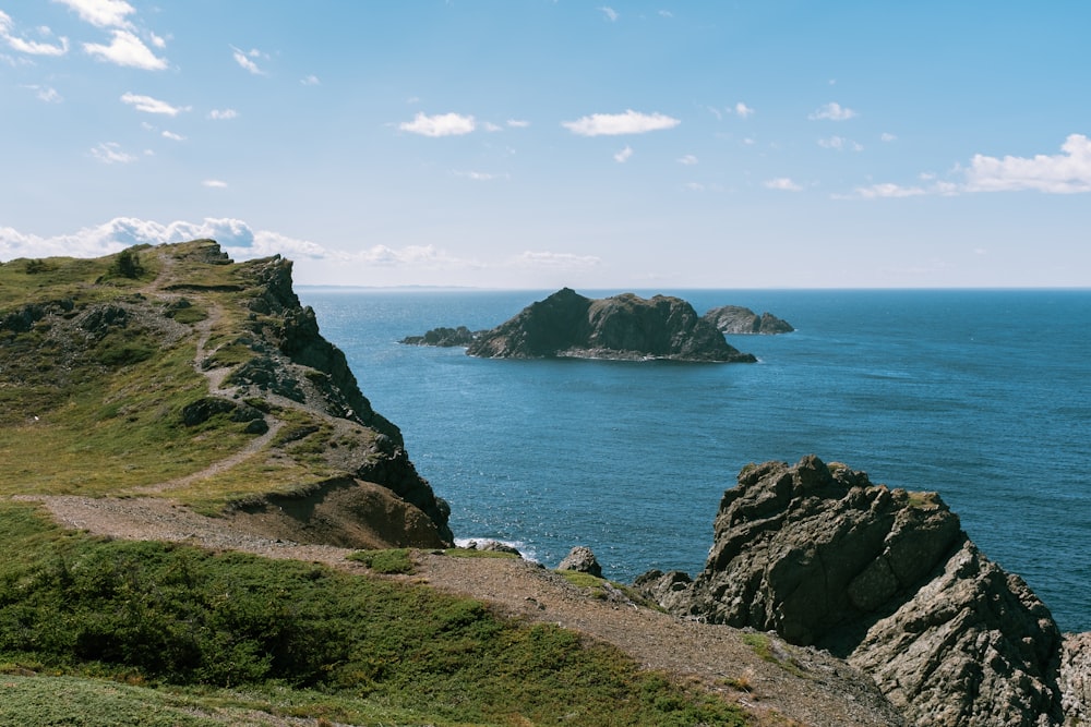 a large body of water sitting next to a lush green hillside