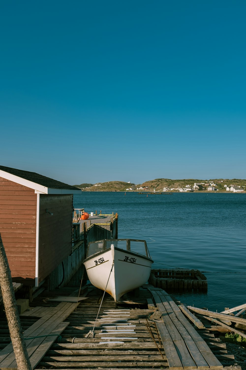 a boat sitting on a wooden dock next to a body of water