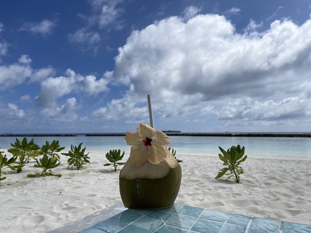 a drink sitting on top of a table on a beach