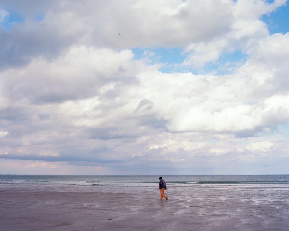 una persona in piedi su una spiaggia che fa volare un aquilone