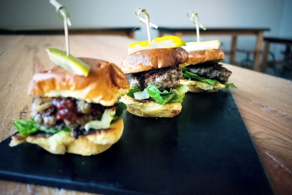 a couple of sandwiches sitting on top of a wooden table