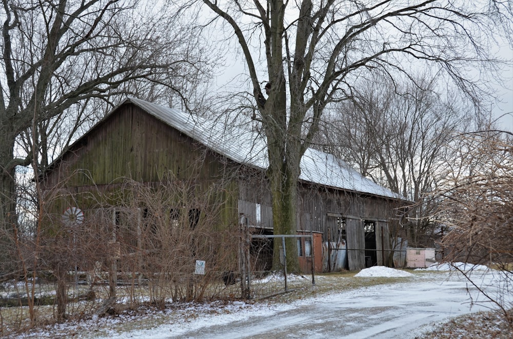 an old barn in the winter with snow on the ground