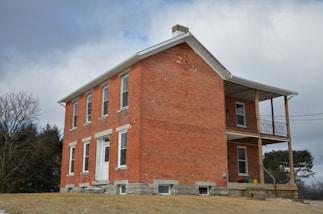 a red brick building with a porch on top of it