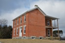 a red brick building with a porch on top of it