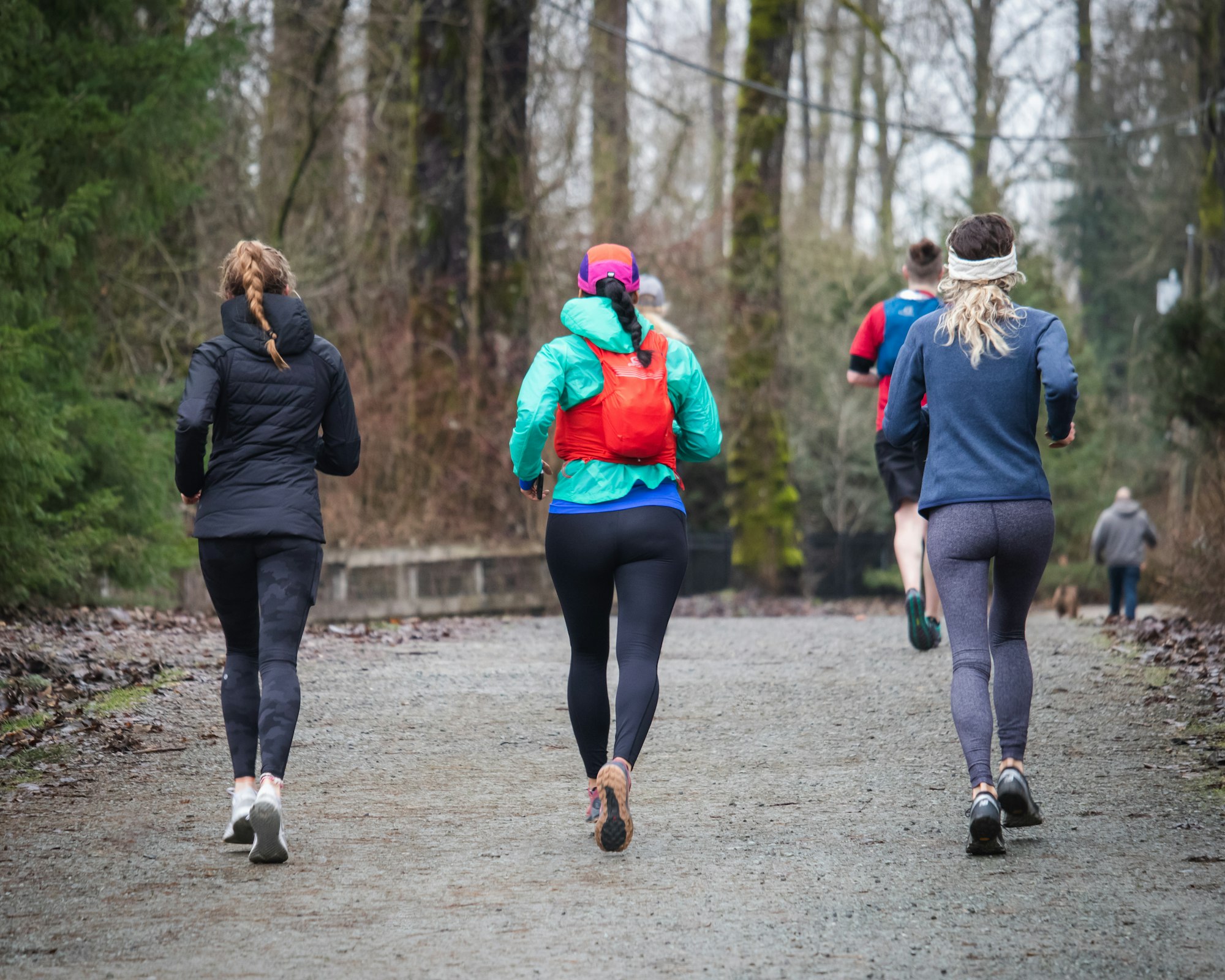 women running in the distance on a trail